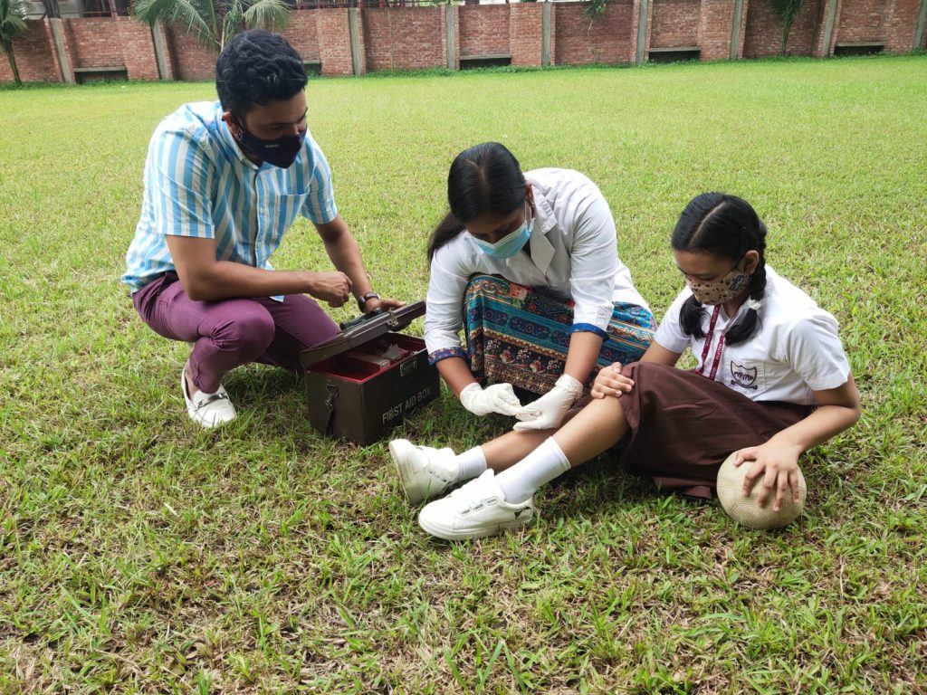 A Playpen teacher giving first aid to a student